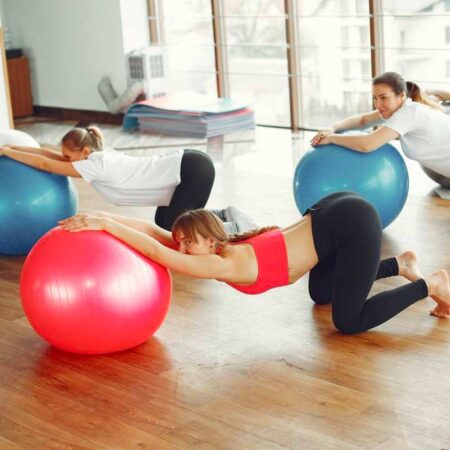 mujeres haciendo pilates con balon en el suelo