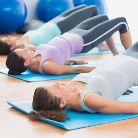 mujeres haciendo-pilates en el suelo